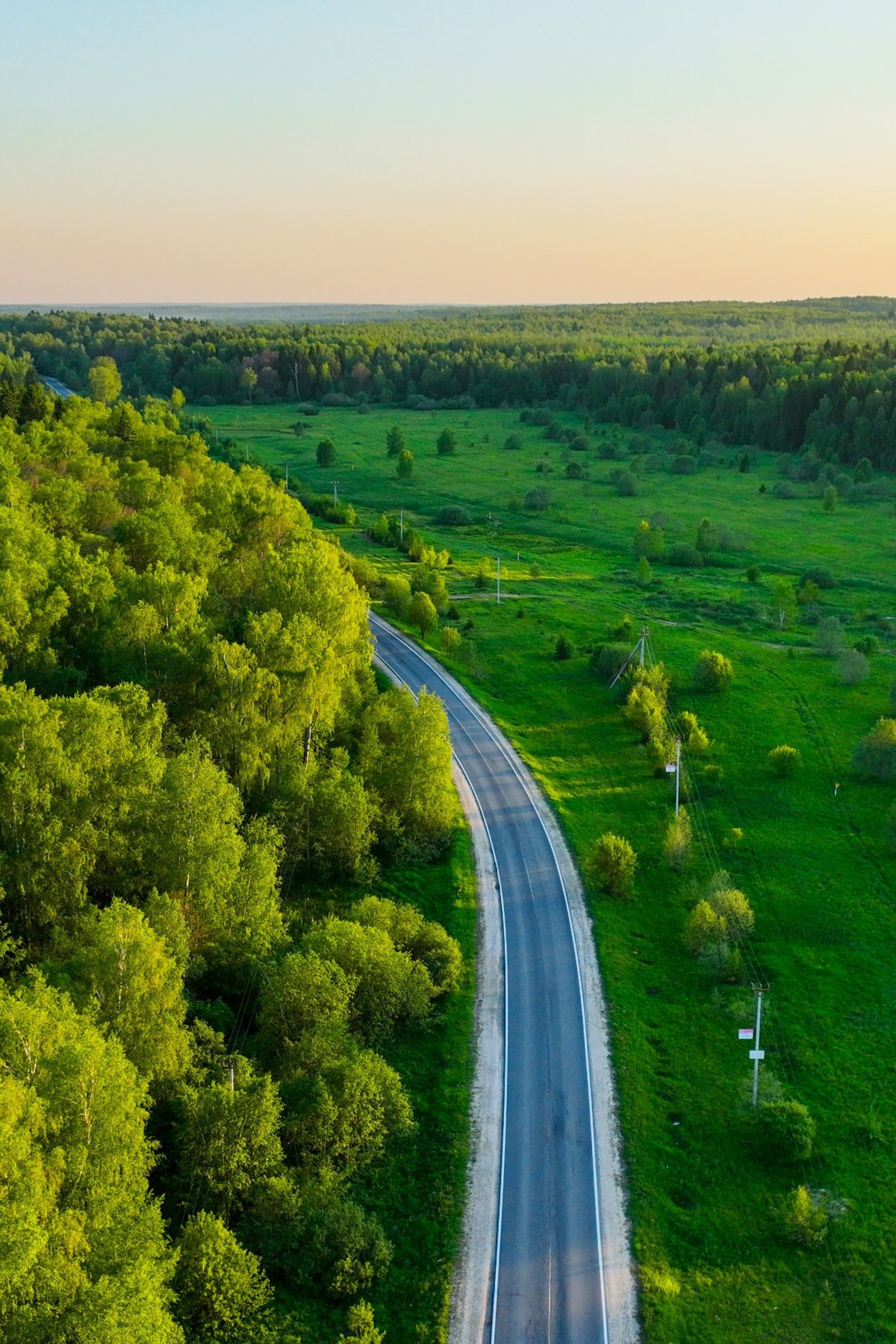 Weg durch weite Landschaft im Sonnenlicht – Symbol für neue Perspektiven und den eigenen Weg
