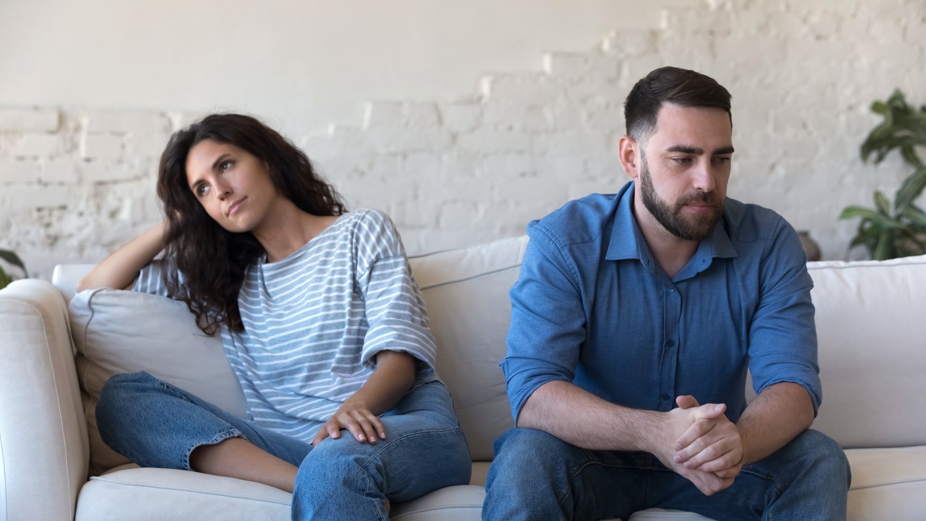 Paar sitzt distanziert auf dem Sofa und vermeidet Blickkontakt – typische Situation beim Konflikte klären in einer Beziehung