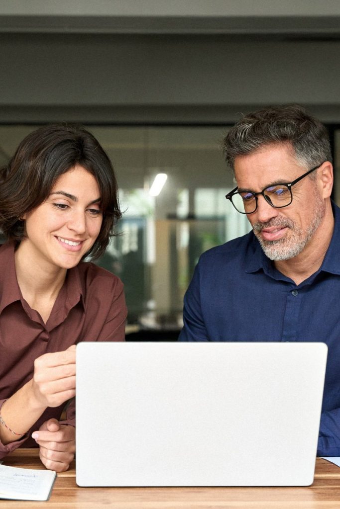 Zwei Personen besprechen gemeinsam Unterlagen und Laptop in einem modernen Büro – Symbolbild für Führungskräfte-Coaching, Teamcoaching und Unternehmensberatung bei Soulgrow