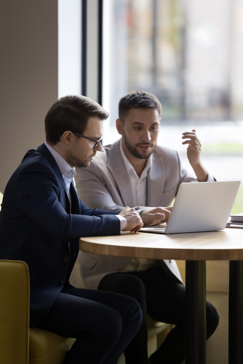 Zwei Männer besprechen gemeinsam Inhalte an einem Laptop – Symbolbild für Führungskräfte-Coaching, Business-Coaching und Sparring bei Soulgrow