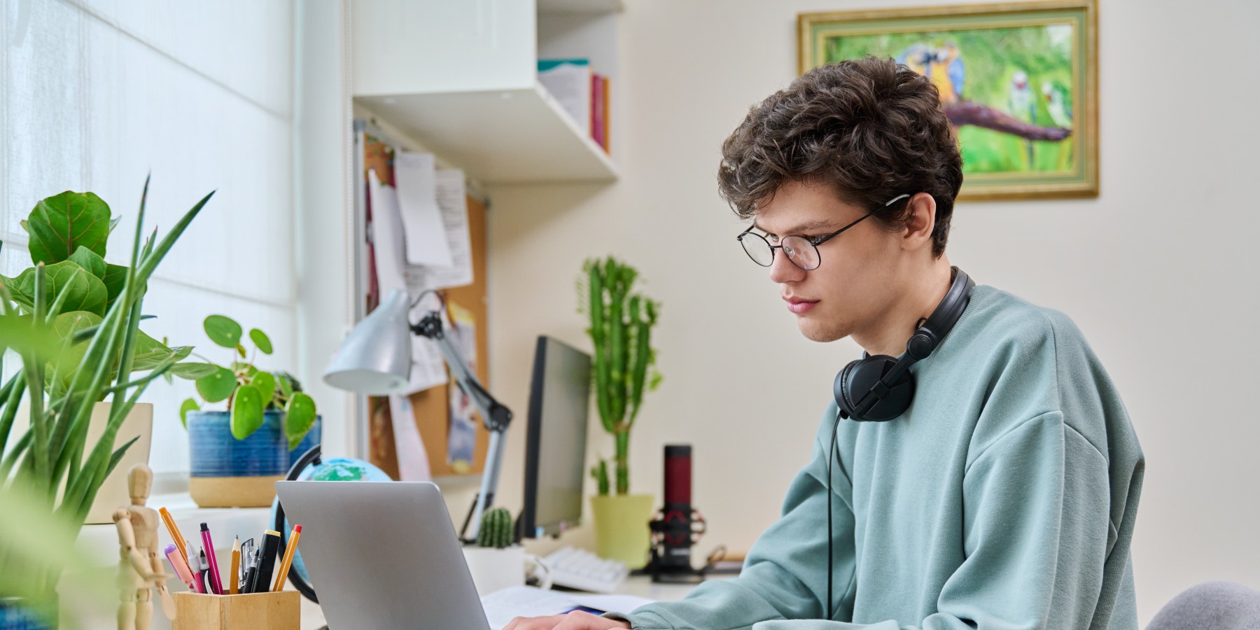 Junger Mann arbeitet am Laptop als Symbol für Bewerbung, Lebenslauf und Online-Bewerbung.