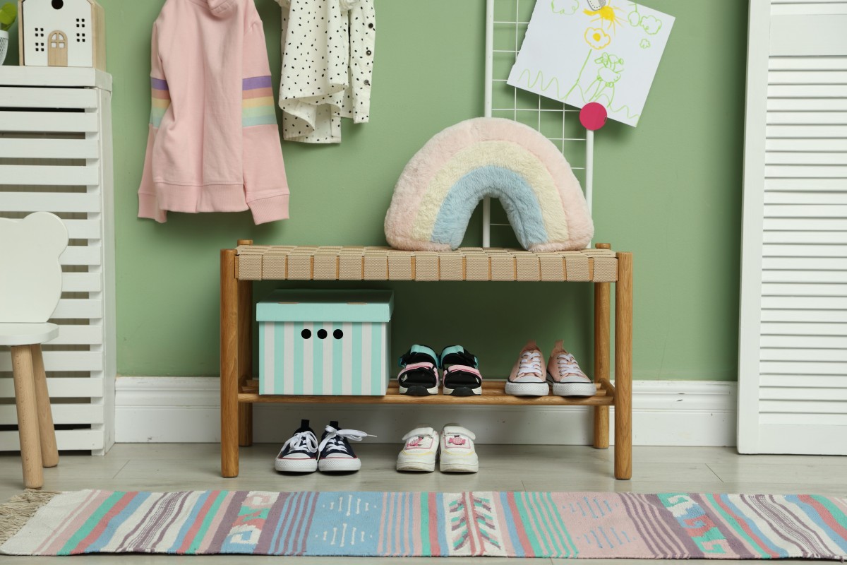 Kinderschuhe und Kleidung an einer Garderobe