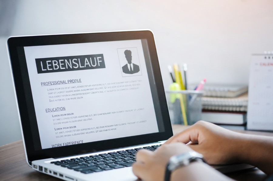 Lebenslauf und Laptop als Symbol für Online-Bewerbung und Bewerbungsunterlagen.