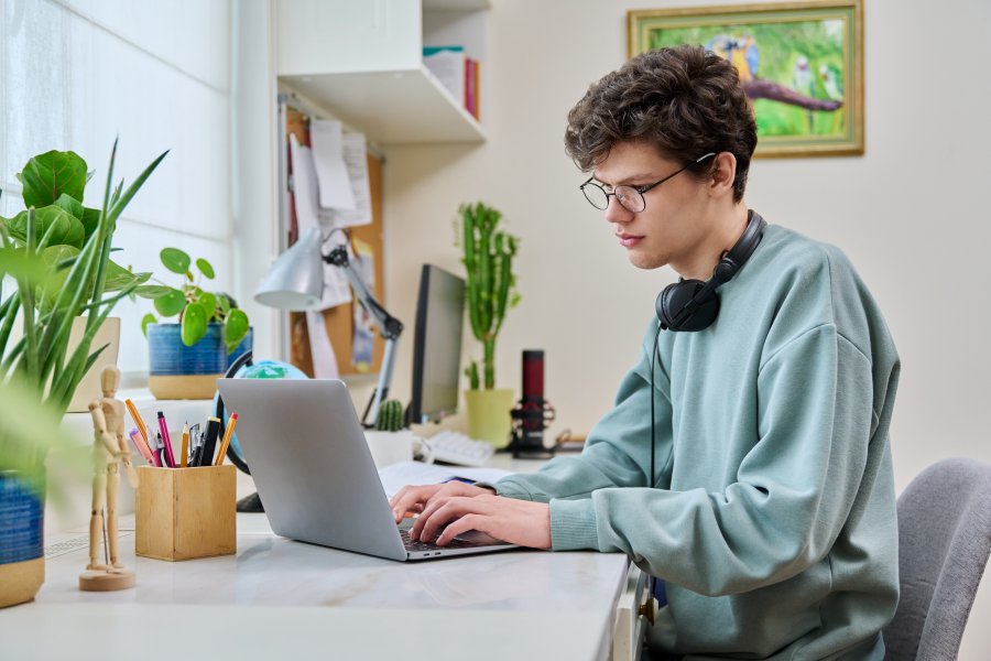 Junger Mann arbeitet am Laptop als Symbol für Bewerbung, Lebenslauf und Online-Bewerbung.
